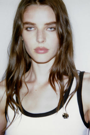 Oberteil mit kontrastfarbenem Besatz und Broschenakzenten