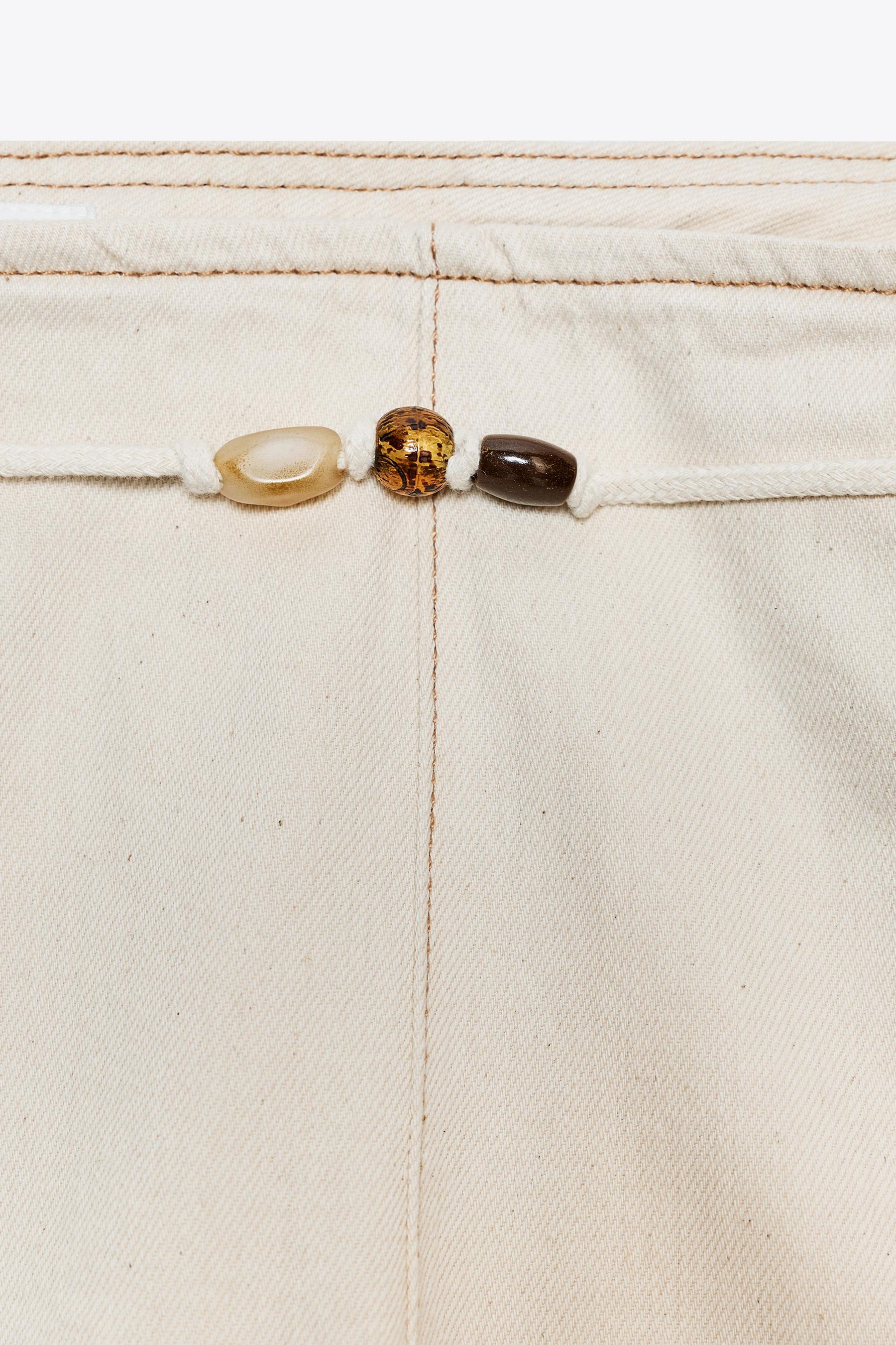 Hochgeschnittene, perlenbesetzte Jeans