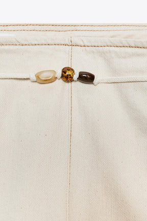 Hochgeschnittene, perlenbesetzte Jeans